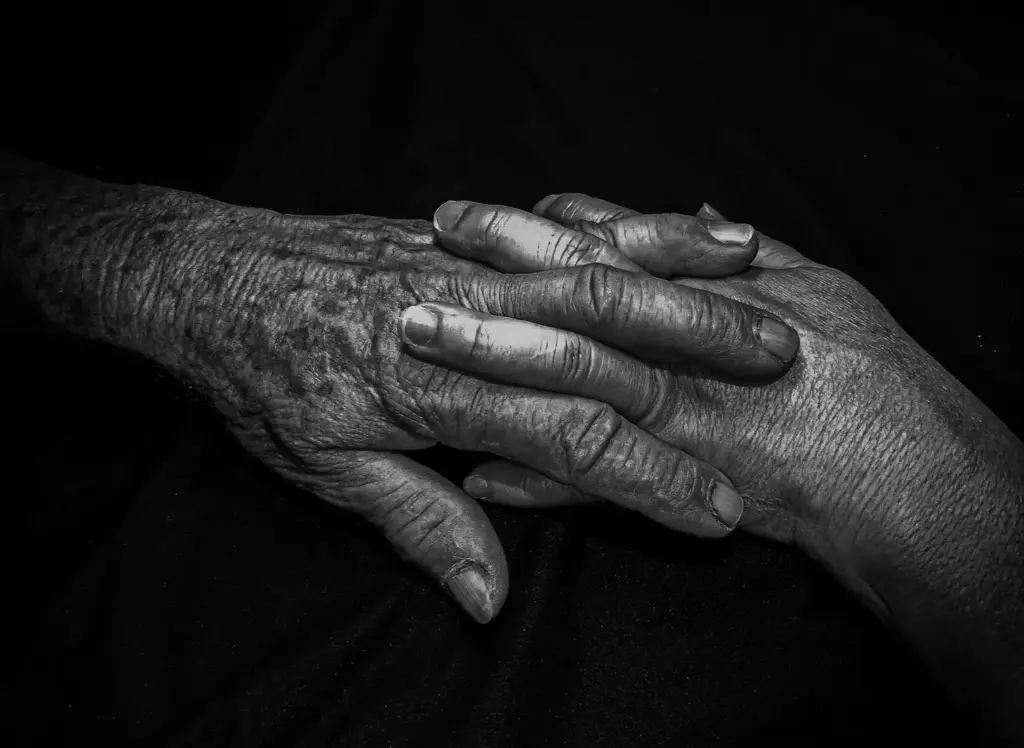 Alzheimer und Demenz: Zwei ältere Menschen halten sich unterstützend an den Händen